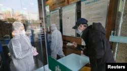 中國武漢封城後一名男子在藥店購買口罩。（2020年1月29日）