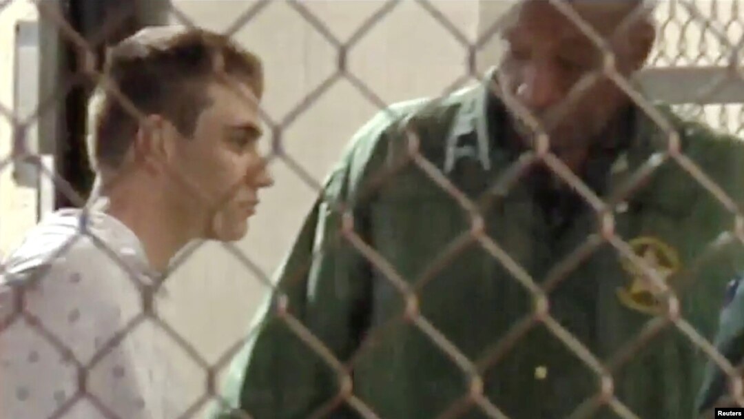 Police escort Nikolas Cruz into Broward County Jail following a shooting incident at Marjory Stoneman Douglas High School, in Fort Lauderdale, Florida, Feb. 15, 2018 in a still image from video. 