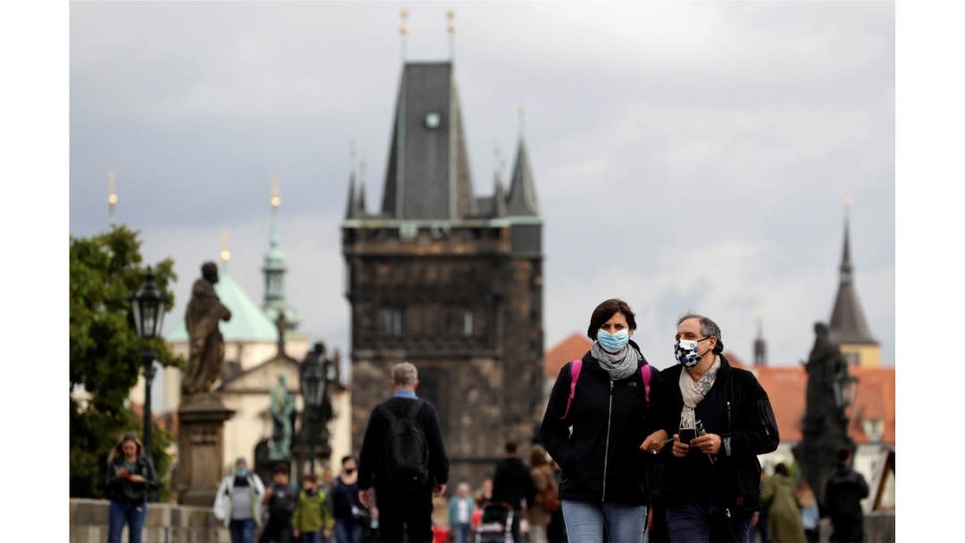 People wearing face masks walk across the medieval Charles Bridge as the spread of the coronavirus disease continues in Prague, Czech Republic, Sept. 25, 2020.