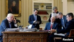 FILE - U.S. President Donald Trump (L-R), joined by Chief of Staff Reince Priebus, VP Mike Pence, senior advisor Steve Bannon, Communications Director Sean Spicer and National Security Advisor Michael Flynn, speaks by phone with Russia's President Vladimir Putin in the Oval Office, the White House, Washington, Jan. 28, 2017.