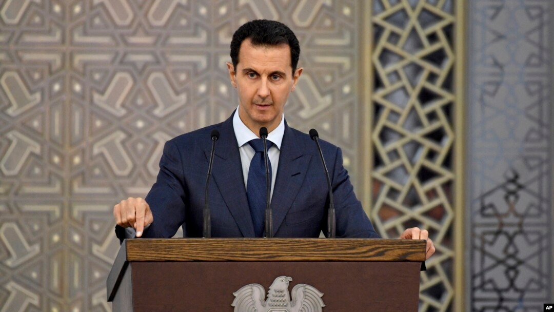FILE - In a photo released by the official Facebook page of the Syrian Presidency, Syrian President Bashar al-Assad speaks to Syrian diplomats, in Damascus, Syria, Aug. 20, 2017.