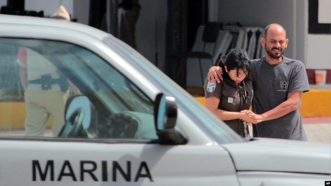 A Mexican navy sailor helps a Cuban migrant after being rescued in Cozumel, Mexico, March 19, 2016.
