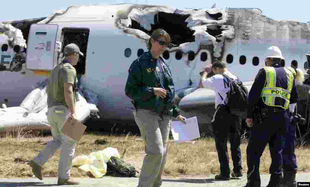 U.S. National Transportation Safety Board (NTSB) investigators stand at the scene of the Asiana Airlines Flight 214 crash site at San Francisco International Airport, July 7, 2013. (NTSB)