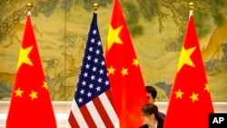 在北京钓鱼台国宾馆，中国工作人员在中美贸易谈判开幕式前调整中美国旗（2019年2月14日）。