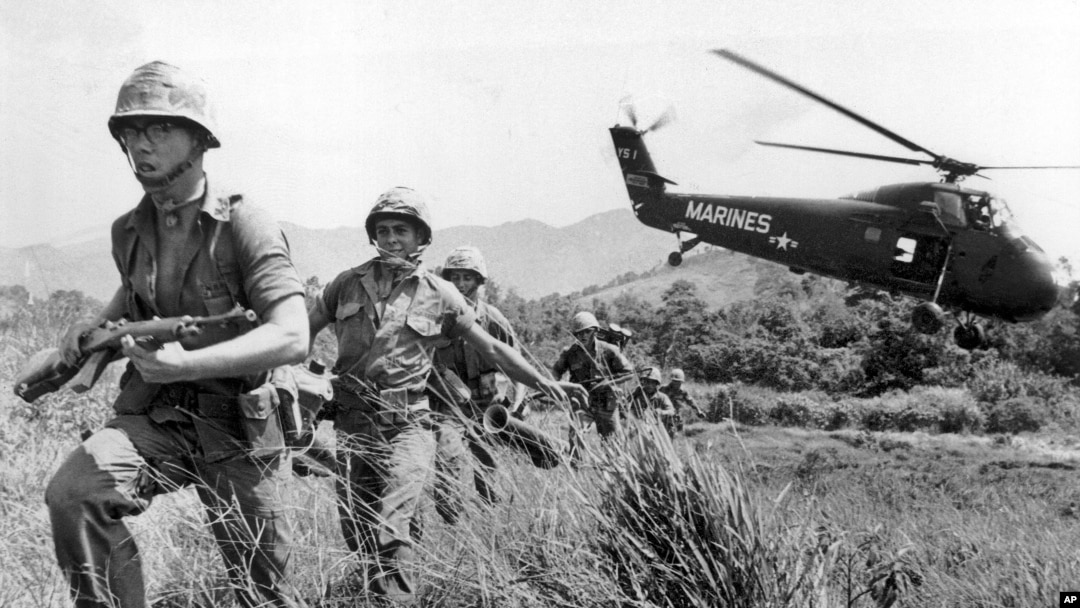 FILE - In this April 28, 1965 file photo, U.S. Marine infantry stream into a suspected Viet Cong village near Da Nang in Vietnam during the Vietnamese war. Filmmaker Ken Burns said he hopes his 10-part documentary about the War, which begins Sept. 17, 2017 on PBS, could serve as sort of a vaccine against some problems that took root during the conflict, such as a lack of civil discourse in America.