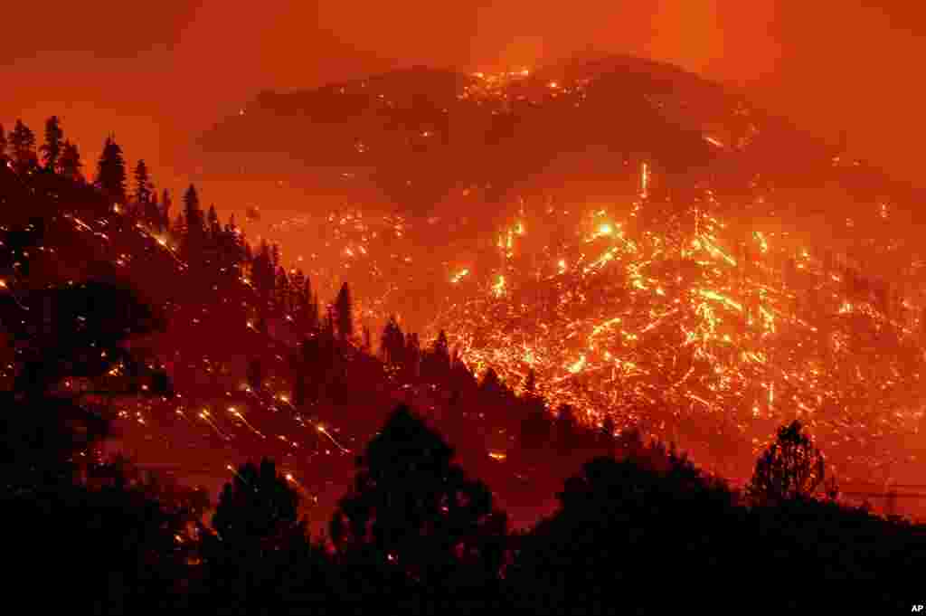 Seen in a long exposure photograph, embers light up hillsides as the Dixie Fire burns near Milford in Lassen County, California, Aug. 17, 2021.