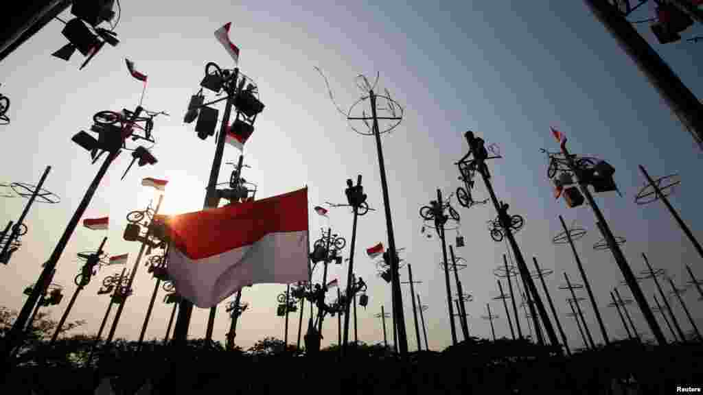 People take part in a game of "Panjat Pinang", where people climb poles to collect prizes, during Independence Day celebrations in Jakarta, Indonesia, Aug. 18, 2018, in this photo taken by Antara Foto.
