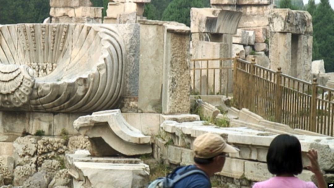 Chinese tourists walk among the marble ruins of the western palace complex inside the Yuanming Yuan, also known as the Old Summer Palace, in Beijing.