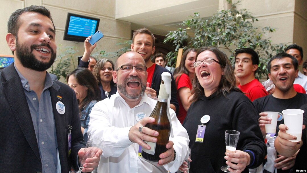 FILE - Members of the activist group Motion of Integration and Gay Liberation celebrate the congressional passage of a bill recognizing civil unions in Valparaiso, Chile, Jan. 28, 2015. Registration of such unions begins this week.