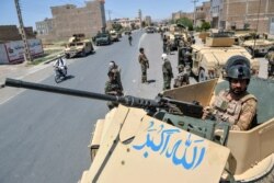 An Afghan National Army commando stands guard on top of a vehicle along the road in Enjil district of Herat province on August 1, 2021, as skirmishes between Afghan National Army and Taliban continue.
