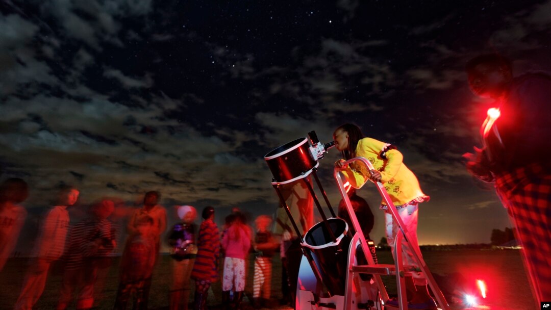 A student looks up at the moon through a telescope, during a visit by The Traveling Telescope to show students the science of astronomy, at St Andrew's School near Molo in Kenya's Rift Valley, Feb. 3, 2017.