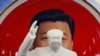 北京天安门附近一个纪念品商店里毛泽东的塑像摆在习近平纪念画盘的前面。（2018年3月1日）