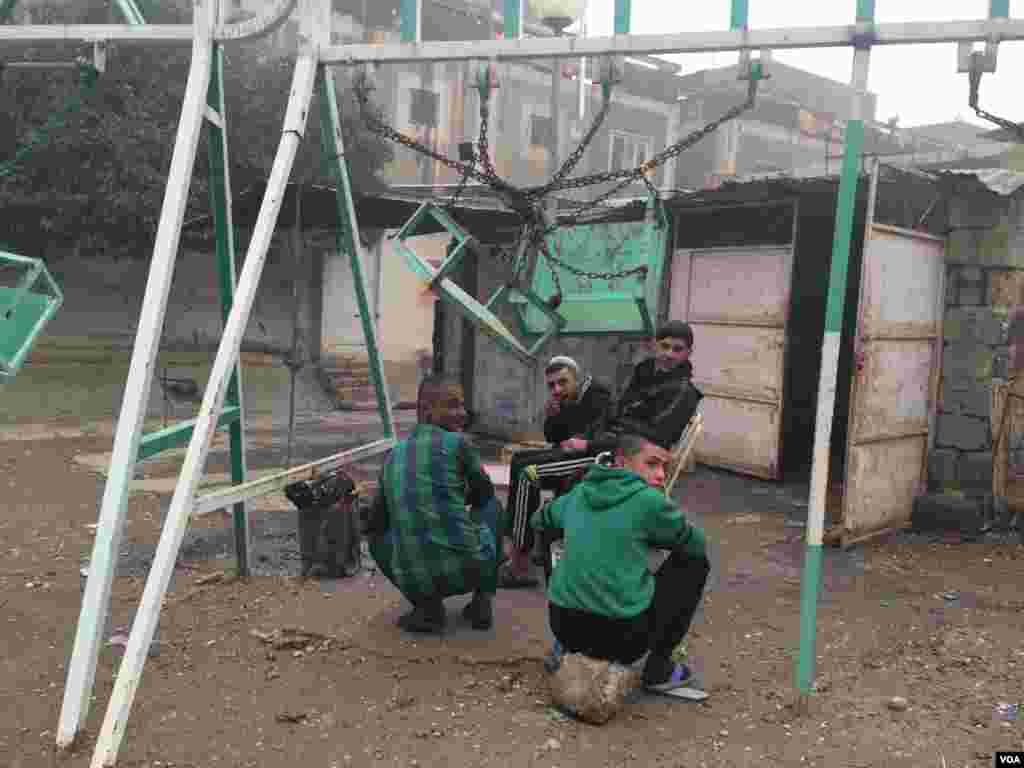 Families gather outside in the ruins of this neighborhood, recently re-captured by the Iraqi Army. By, night, they say mortar fire rains down and they all stay indoors on Dec. 2, 2016 in Mosul, Iraq. (H.Murdock/VOA)