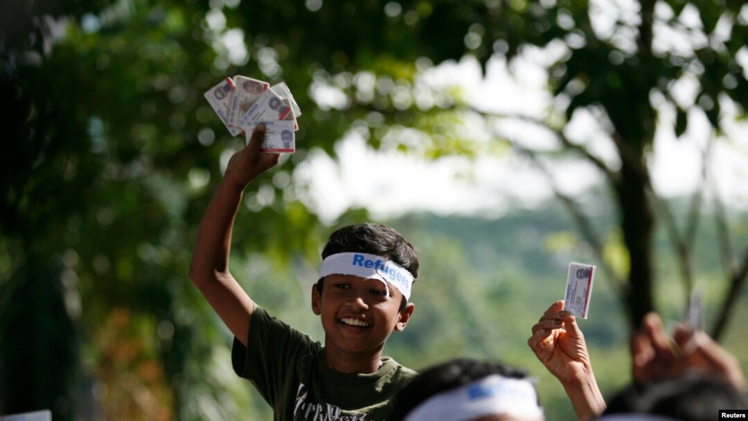 A refugee from Myanmar shows refugee status cards during a demonstration outside the United Nations High Commissioner (UNHCR) office in Kuala Lumpur Dec. 3, 2008.