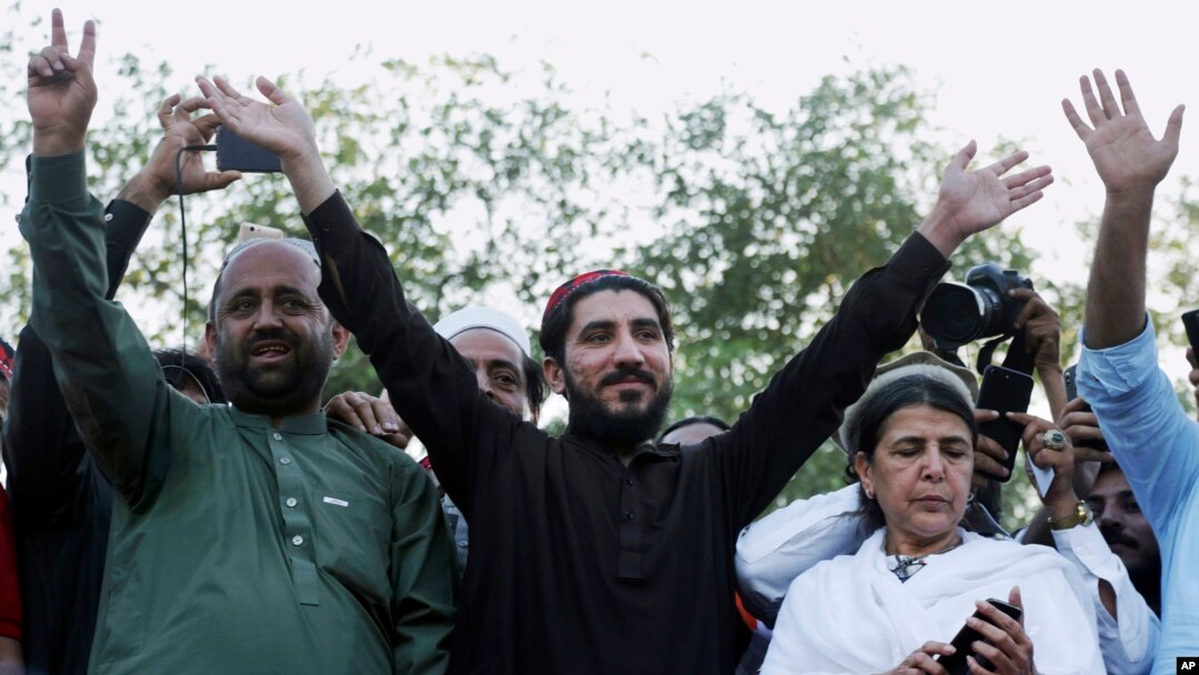 FILE - Manzoor Pashteen, center, leader of Pakistan’s Pashtun Tahafuz Movement (PTM), waves to his supporters during a rally in Lahore, Pakistan, April 22, 2018. 