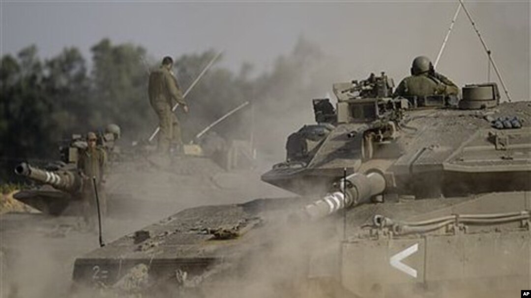 An Israeli tank drives next to the border between Israel and the southern Gaza Strip, April 8, 2011