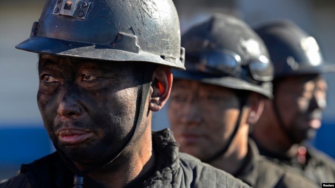 FILE - Miners wait in lines to shower during a break near a coal mine in Heshun county, Shanxi province.