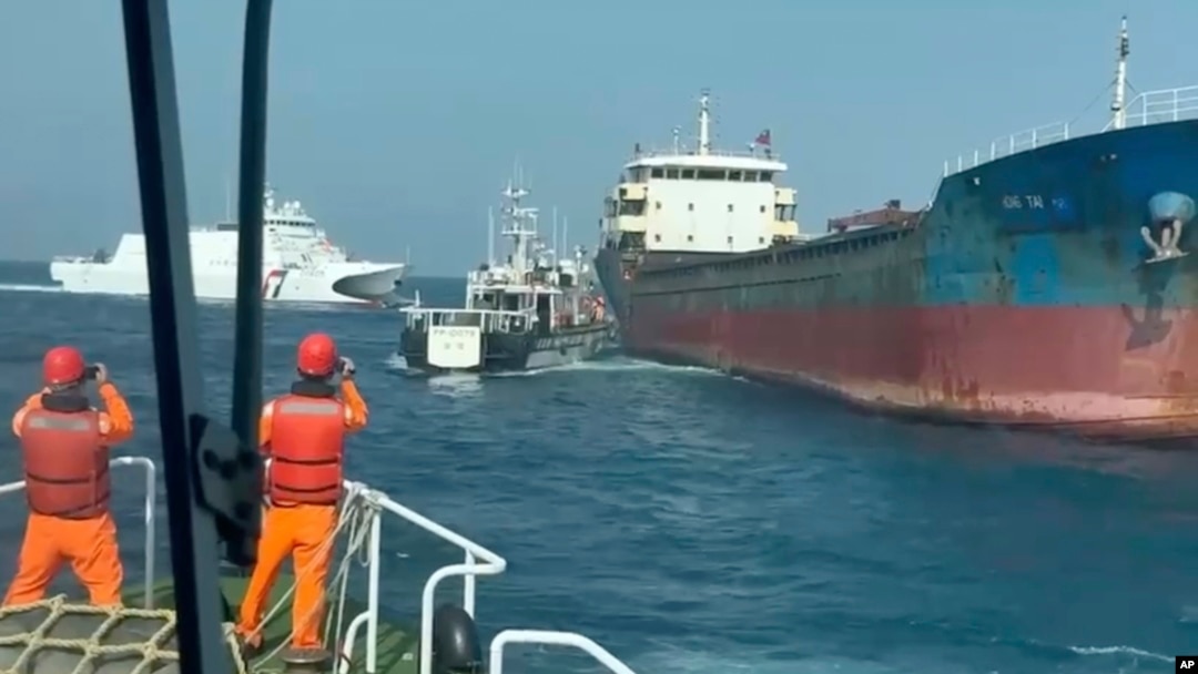 In this photo made from video released by the Taiwan Coast Guard, Taiwanese Coast Guard vessels prepare to board Togolese-flagged cargo ship Hongtai suspected of severing an undersea communications cable, Feb 25, 2025. 