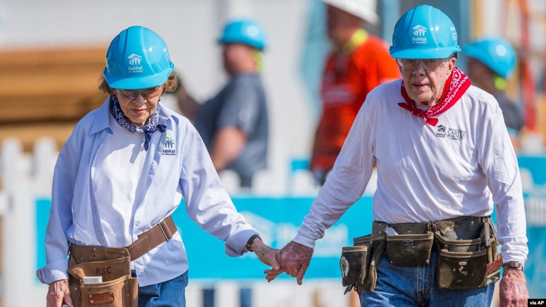 FILE - Former President Jimmy Carter holds hands with his wife Rosalynn Carter as they work with other volunteers for Habitat for Humanity in Mishawaka, Indiana, Aug. 27, 2018. They are celebrating their 75th wedding anniversary. (Robert Franklin/South Bend Tribune)