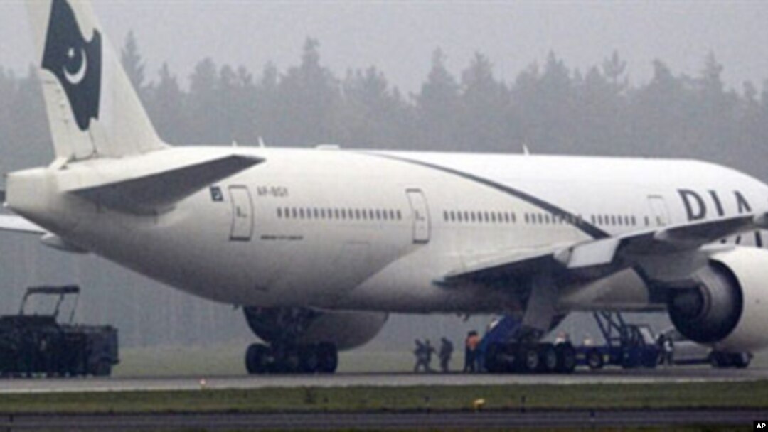 Two anti-terrorist policemen (C) secure one of the passengers as a Pakistan International Airlines Boeing 777 is evacuated at Stockholm Arlanda International airport, 25 Sep 2010