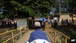 Un migrante centroamericano de Honduras viste la bandera de su nación durante la caravana anual de Migrantes de la Cruz o "Viacrucis", organizada por el grupo activista "Pueblo Sin Fronteras".