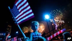 ARCHIVO - Espectadores observan desde el distrito de Queens de Nueva York cómo se lanzan los fuegos artificiales sobre el East River y el Empire State Building durante el espectáculo de fuegos artificiales del 4 de julio de Macy's, el 4 de julio de 2021.