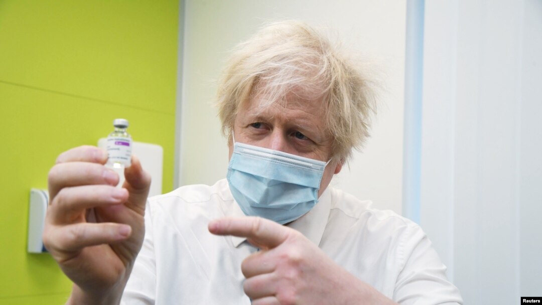 Britain's Prime Minister Boris Johnson holds a vial of AstraZeneca coronavirus vaccine during a visit to a coronavirus vaccination center at the Health and Well-being Centre in Orpington, South-East of London, Britain, Feb. 15, 2021.