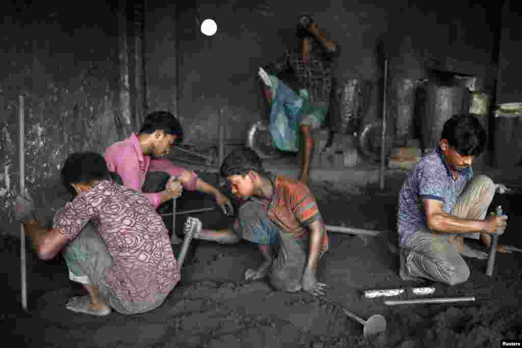 Workers, including children, perform their duties at a dockyard in Dhaka, Bangladesh.
