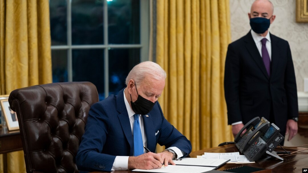 FILE - Secretary of Homeland Security Alejandro Mayorkas looks on as President Joe Biden signs an executive order on immigration, in the Oval Office of the White House, Feb. 2, 2021, in Washington.