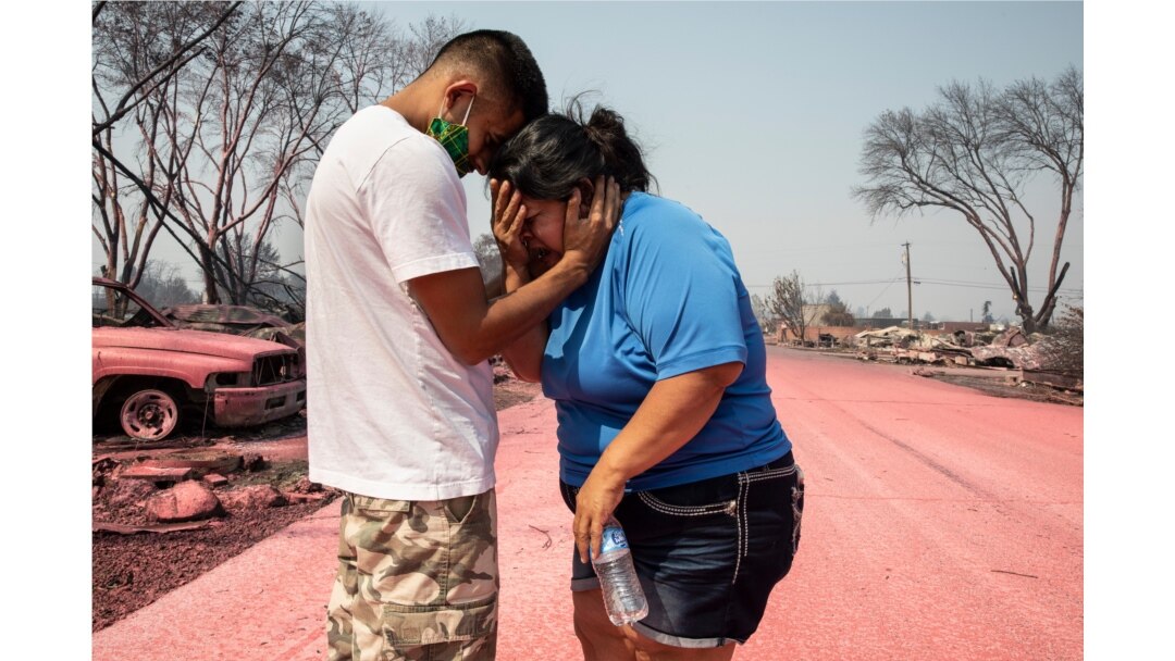 Dora Negrete es consolada por su hijo Hector Rocha después que su vivienda en el parque de casas rodantes Talent Mobile Estates, se quemara en un incendio forestal el jueves 10 de septiembre de 2020, en Talent, Oregón.