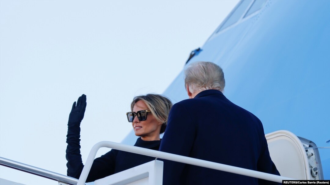 Donald Trump e Melania Trump acenam ao embarcarem no avião presidencial a caminho da Flórida no final da presidência Trump