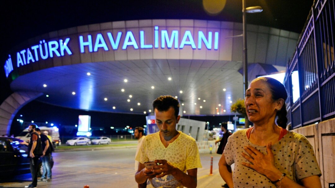People gather at the entrance to Istanbul's Ataturk airport in the early-morning hours of June 29, 2016, after suicide bombers struck in the terminal, killing dozens of people and wounding many others.