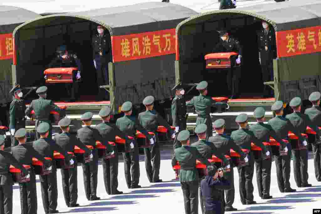 Chinese honor guards carry caskets containing the remains of Chinese soldiers killed during the 1950-53 Korean War at the Shenyang Taoxian International Airport in Shenyang in China's northeastern Liaoning province after the remains were returned from South Korea for permanent burial.