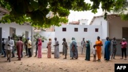 Eleitores aguardam na fila à porta de uma mesa de voto em Dakar, a 17 de novembro de 2024,