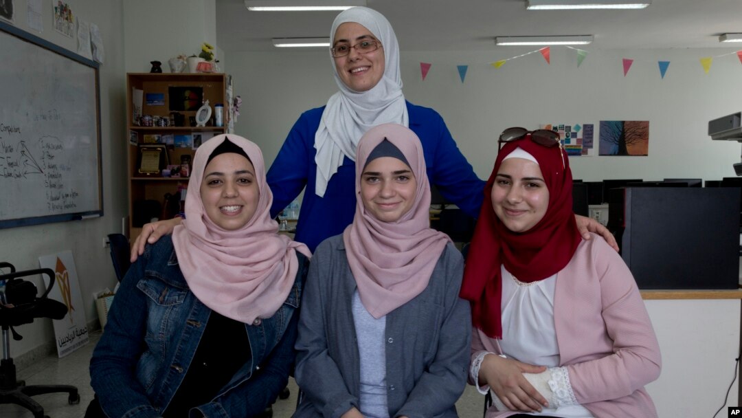 Tamara Awaysa, 17, left, Wassan al-Sayyed,17, center and Massa Halawa,16, right, pose for a photo with their mentor Yamama Shakaa in the West Bank city of Nablus. For the 11th graders from the Israeli-occupied West Bank, the ticket of admission to the World Pitch Summit signals a particularly dramatic leap because of the limited opportunities at home.