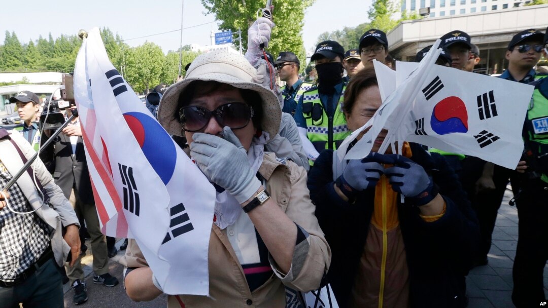 Supporters of former South Korean President Park Geun-hye weep to demand her release as a bus carrying her arrives at the Seoul Central District Court in Seoul, South Korea, May 25, 2017. 