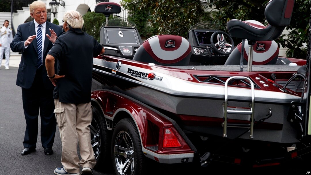 El presidente Donald Trump habla con Jimmy Houston de Ranger Boats mientras participa en una exhibición durante una "Muestra de Productos Made in America" en la Casa Blanca, el lunes 23 de julio de 2018, en Washington. (AP Photo / Evan Vucci).