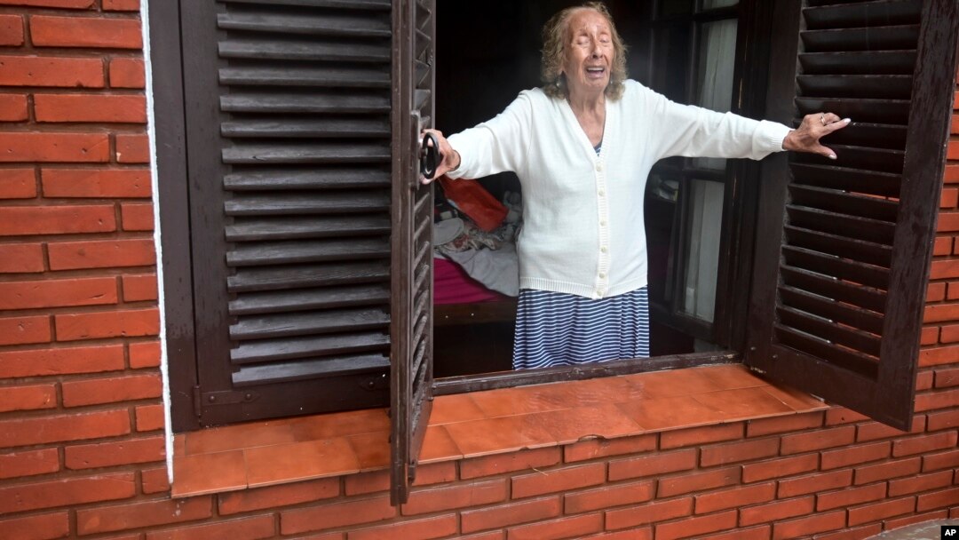 Una mujer mira desde su casa hacia la calle inundada después de una tormenta en Bahía Blanca, Argentina, el viernes 7 de marzo de 2025.