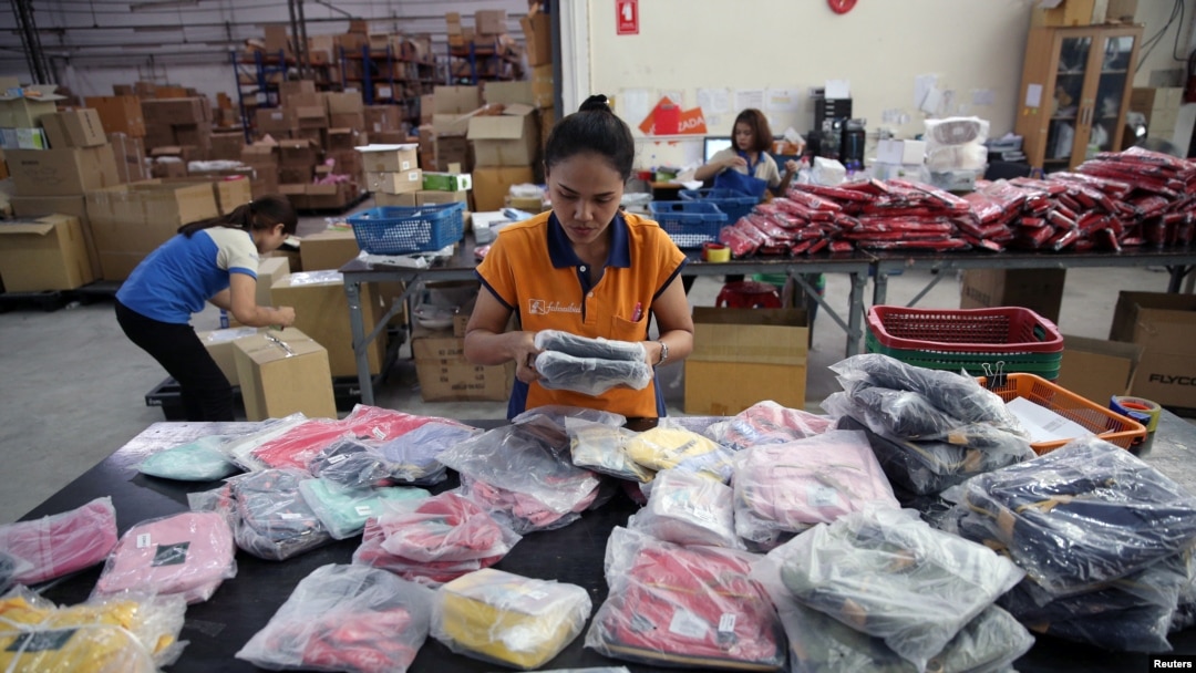 FILE - Workers pack bags with goods imported from China at a company in Bangkok, Thailand, Aug. 7, 2018.