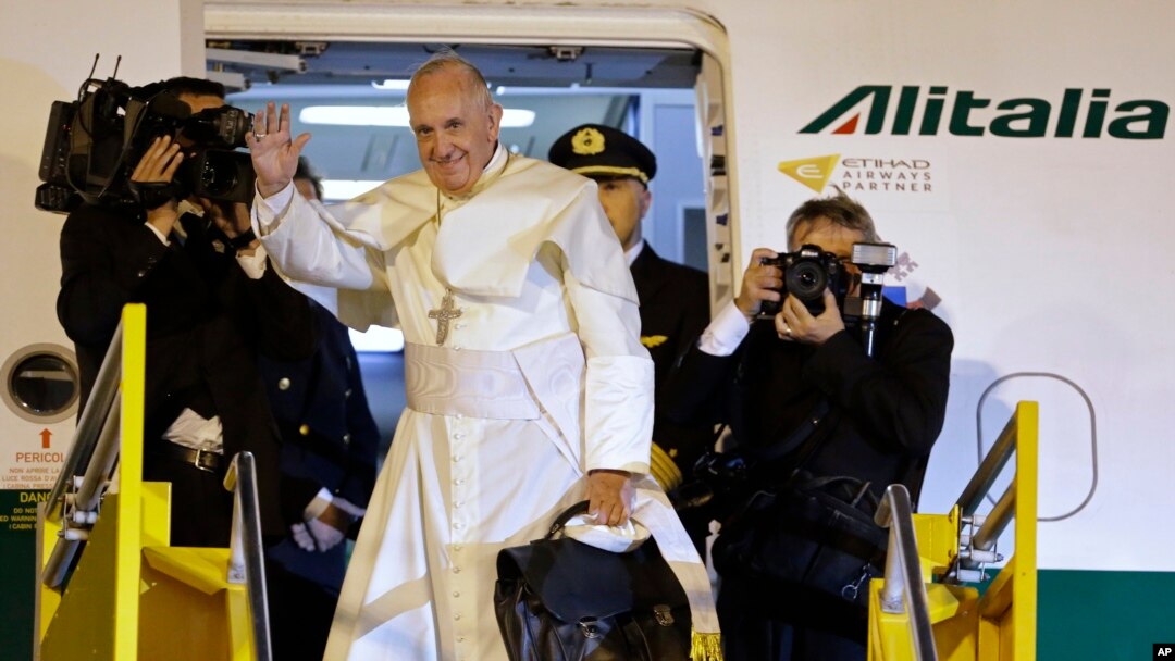 Pope Francis waves good-bye after climbing the stairs to the plane taking him back to Rome, in Asuncion, Paraguay, July 12, 2015.