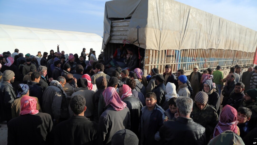 FILE - Syrians fleeing the conflicts in the A'zaz region congregate at the Bab al-Salam border gate, Syria, Feb. 5, 2016. 