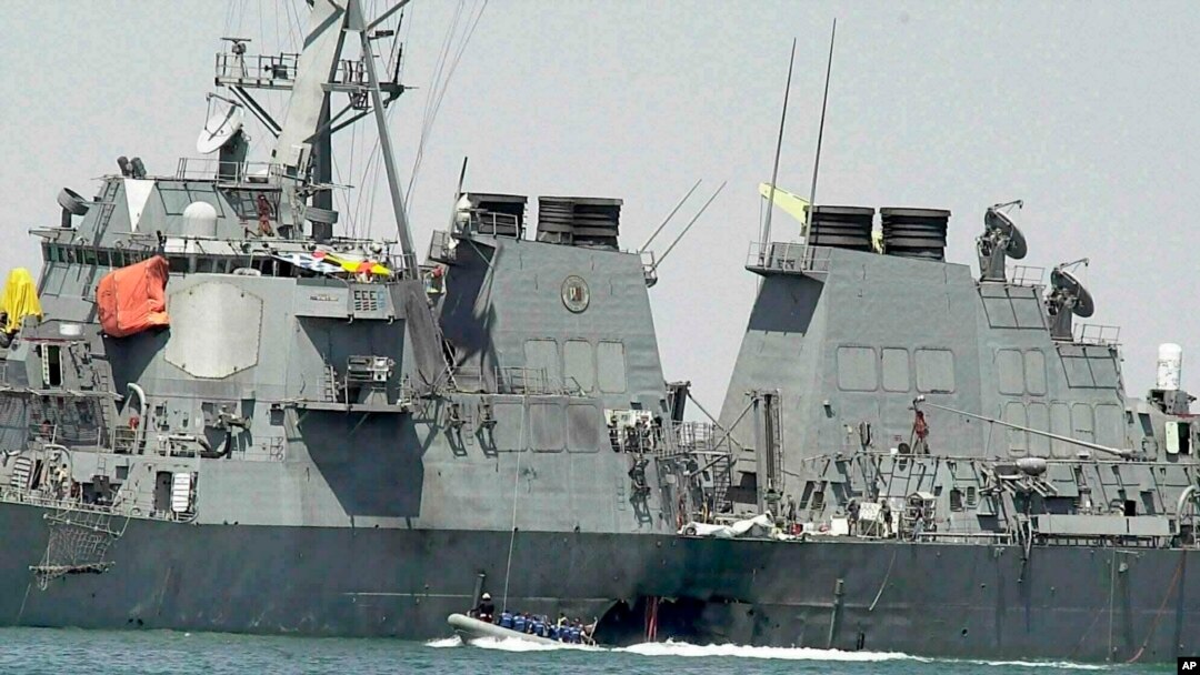 FILE - In this Oct. 15, 2000 file photo, experts in a speed boat examine the damaged hull of the USS Cole at the Yemeni port of Aden after an al-Qaida attack that killed 17 sailors.