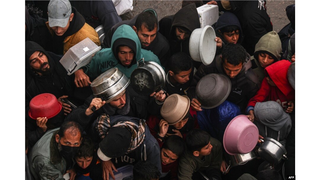Palestinians receive food rations at a donation point at a camp for internally displaced people in Rafah, Gaza Strip, on Feb. 2, 2024.