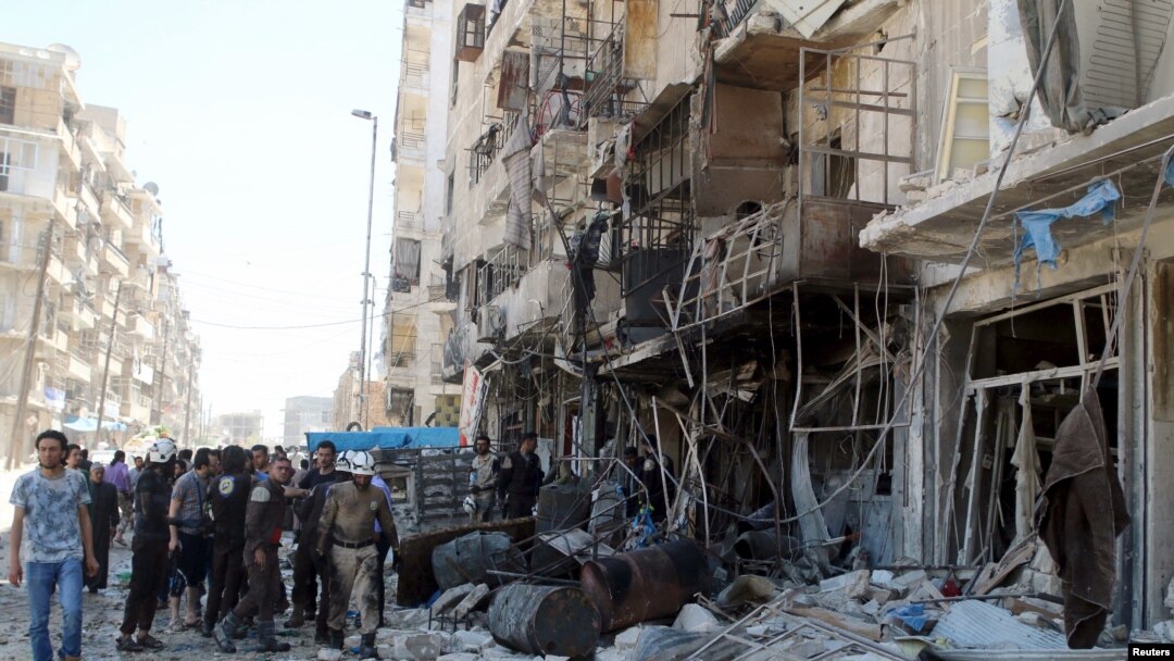Residents and civil defense members inspect a damaged building after an airstrike on the rebel-held Tariq al-Bab neighborhood of Aleppo, Syria, April 23, 2016. 
