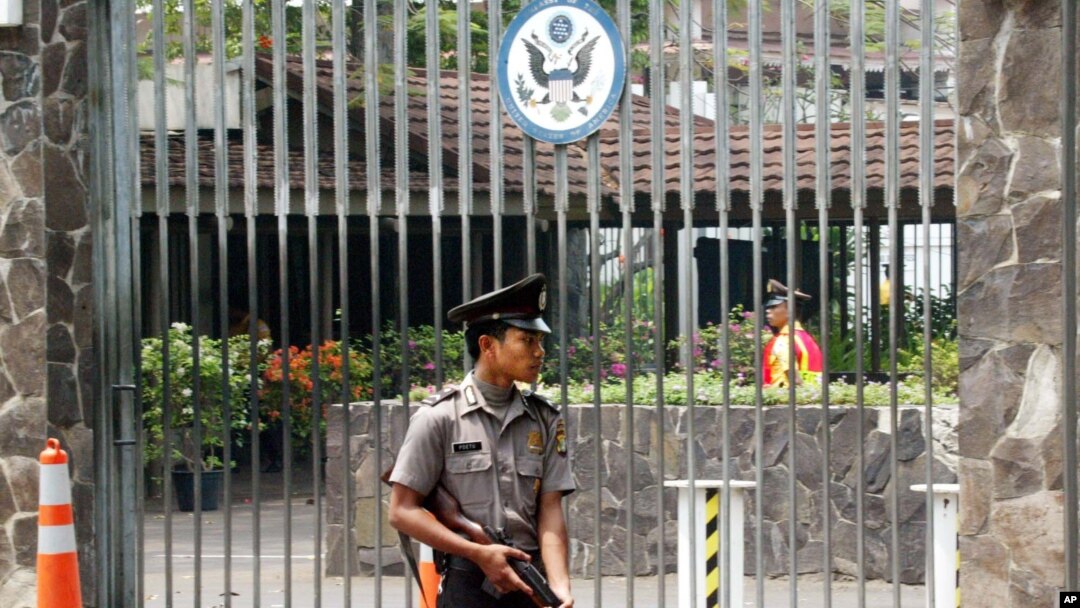 FILE - An armed Indonesian police officer stands guard at the gate of the U.S. embassy in Jakarta, Indonesia. 