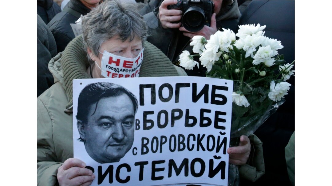 FILE - A woman holds a placard with a portrait of Sergei Magnitsky during an unauthorized rally in central Moscow December 15, 2012. The placard reads "Died fighting a system of thievery."