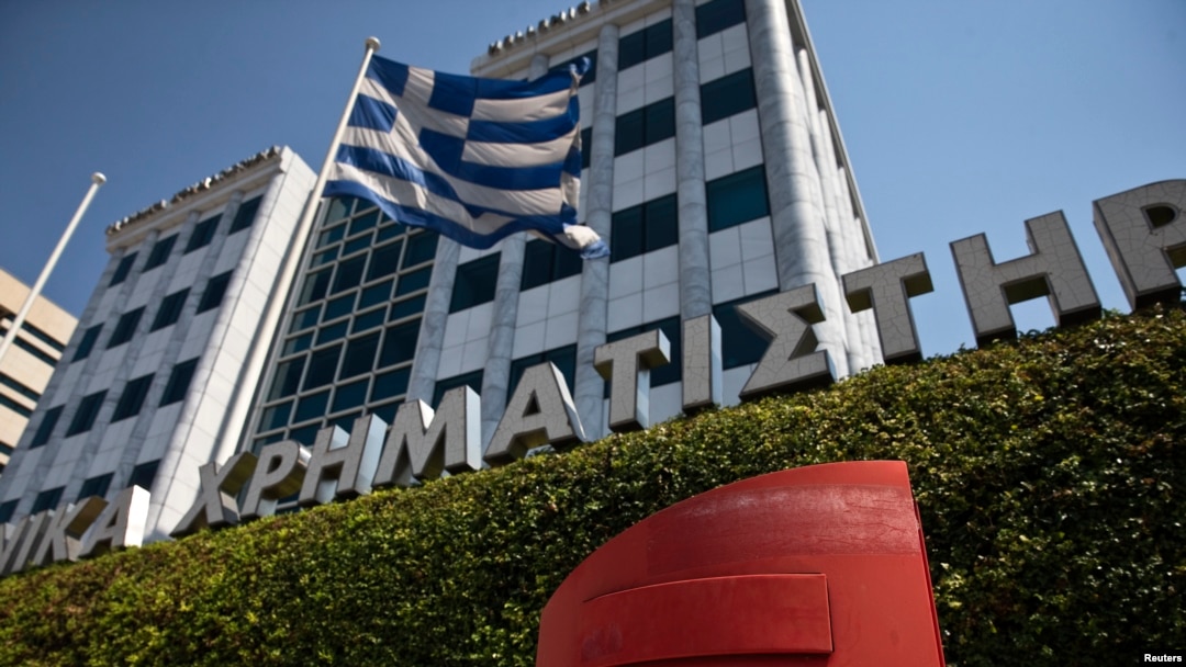 FILE - A Greek flag flutters outside the Athens stock exchange, Greece.