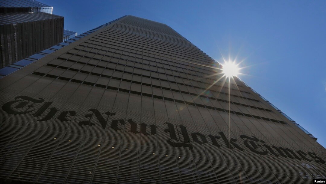 FILE - The sun peaks over the New York Times building in New York, Aug. 14, 2013. 