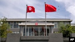 中国国旗和香港特区旗帜在港府办公楼前飘扬。（2020年6月30日）
