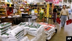 A hardware store employee walks past a pallet of ice melt while restocking a display of snow shovels in Winston-Salem, North Carolina, Jan. 20, 2016. 